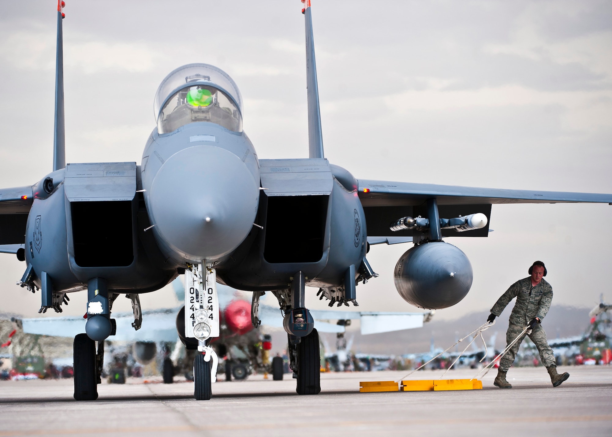 U.S. Air Force Senior Airman Andrew Sigler, 366th Aircraft Maintenance Squadron crew chief, Mountain Home Air Force Base, Idaho, pulls chocks from underneath an F-15E Strike Eagle during Red Flag 14-1 Jan. 30, 2014, at Nellis Air Force Base, Nev. The U.S. Air Force’s premier exercise gives aircrews and ground crews the opportunity to experience realistic, stressful combat situations in a controlled environment to increase their ability to complete their missions and return home. (U.S. Air Force photo/Senior Airman Brett Clashman)