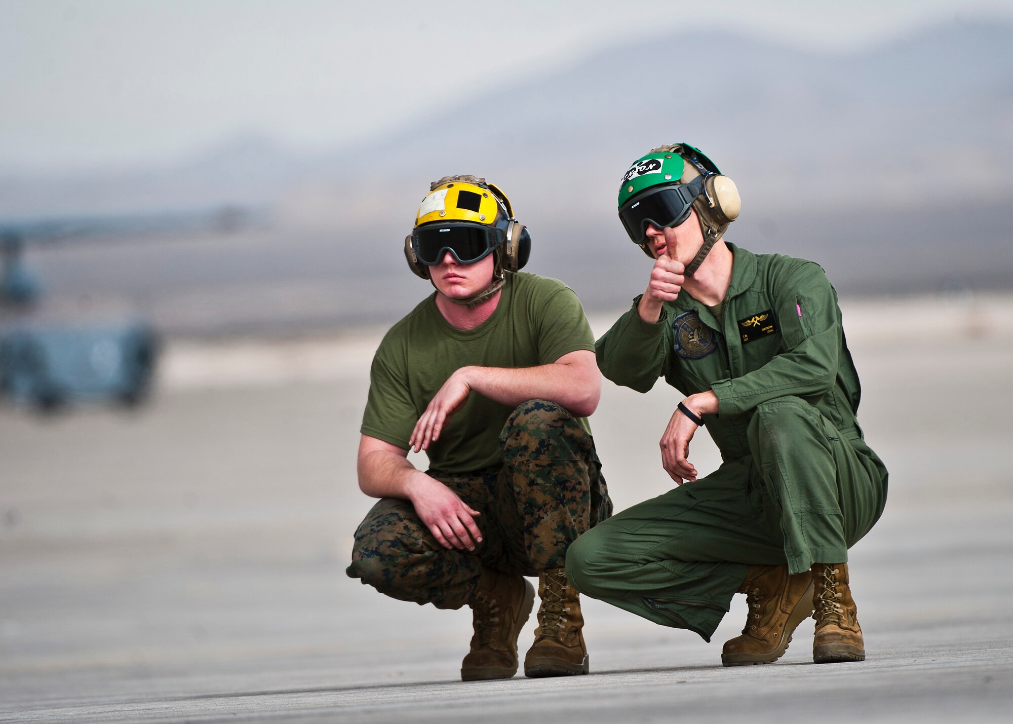 U.S. Marine Corps Cpl. Josh Gollnick (left), and Sgt. Eric Swenson, 2nd Marine Aircraft Wing, Marine Tactical Electronic Warfare Squadron 4 point checkers, communicate with fellow Marines using hand signals during Red Flag 14-1 Jan. 30, 2014, at Nellis Air Force Base, Nev. Red Flag gives U.S. service members and allied partners an opportunity to experience realistic combat scenarios to prepare and train in the event of future conflicts or war. (U.S. Air Force photo/Senior Airman Brett Clashman)