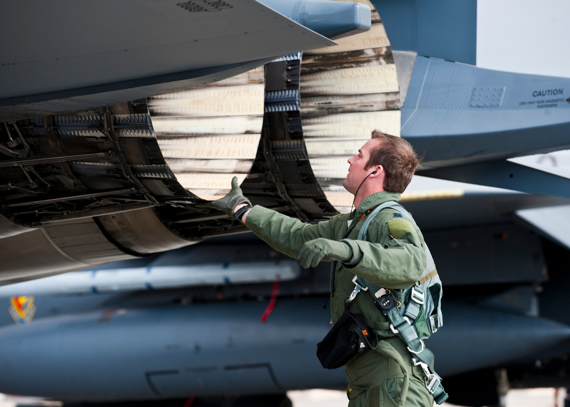 U.S. Air Force Capt. Tom Coker, 391st Fighter Squadron pilot, from Mountain Home Air Force Base, Idaho, inspects the exhaust nozzle of an F-15E engine during Red Flag 14-1 Jan. 30, 2014, at Nellis AFB, Nev. Red Flag provides realistic combat scenarios and conditions for pilots and ground crews. Practicing these scenarios in a controlled environment increases the combat effectiveness of aircrews and ground crews for any future potential real-world conflicts or wars. (U.S. Air Force photo by Airman 1st Class Thomas Spangler)