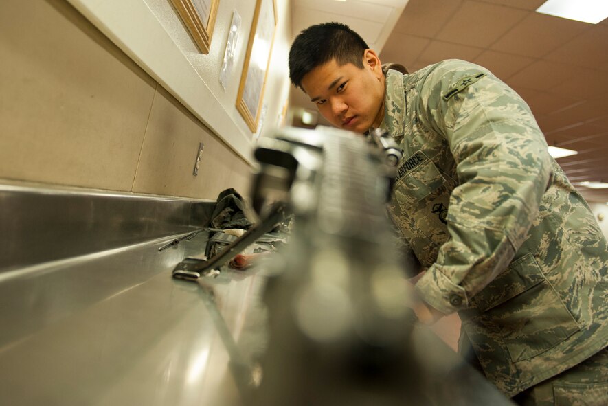 Airman Michael Wang, 5th Security Forces Squadron defender, inspects the cleanliness of an M-249 weapon at Minot Air Force Base, N.D., Jan. 30, 2014. Proper cleaning is essential to the proper function of the weapon. (U.S. Air Force photo/Airman 1st Class Apryl Hall)