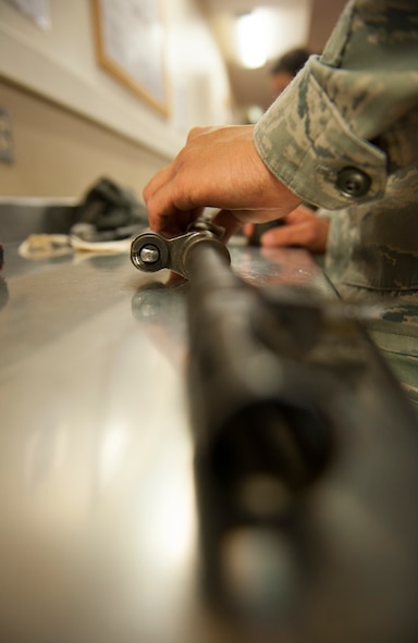 A 5th Security Forces Squadron defender cleans the barrel of an M-249 weapon at Minot Air Force Base, N.D., Jan. 30, 2014. Security forces Airmen are required to clean weapons once a month. (U.S. Air Force photo/Airman 1st Class Apryl Hall)