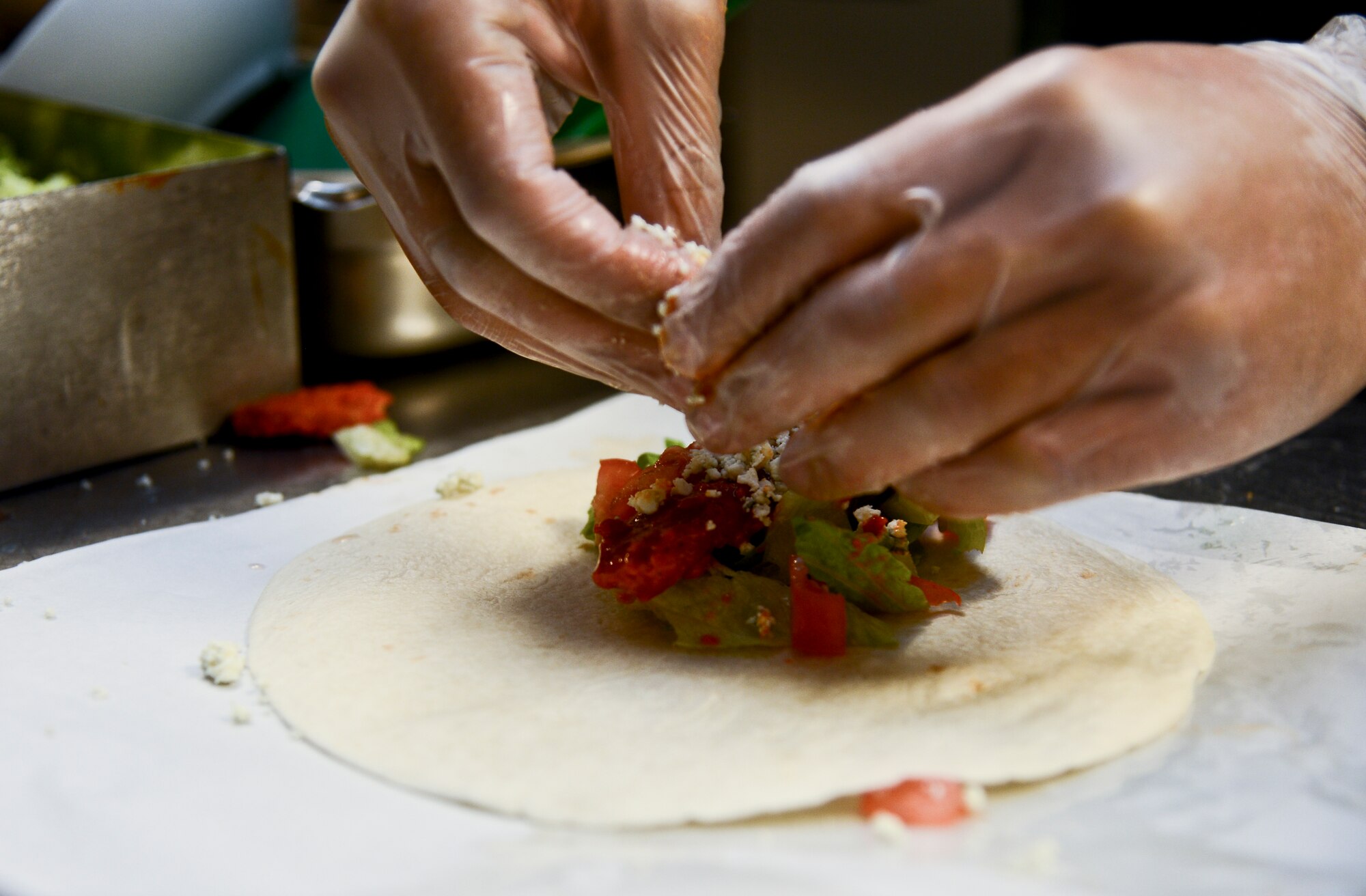 Blue cheese is placed on a buffalo chicken wrap at the Diners Reef on MacDill Air Base, Fla. Diner’s Reef serves more than 276,000 active, reseve, guard and civilians annually. (U.S. Air Force photo by Senior Airman Melanie Bulow-Gonterman/Released)  