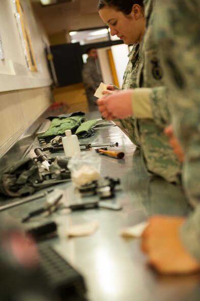 Airman 1st Class Gabrielle Chaconas, 5th Security Forces Squadron defender, cleans a disassembled weapon at Minot Air Force Base, N.D., Jan. 30, 2014. Cleaning the weapon is important for the weapon’s function. (U.S. Air Force photo/Airman 1st Class Apryl Hall)