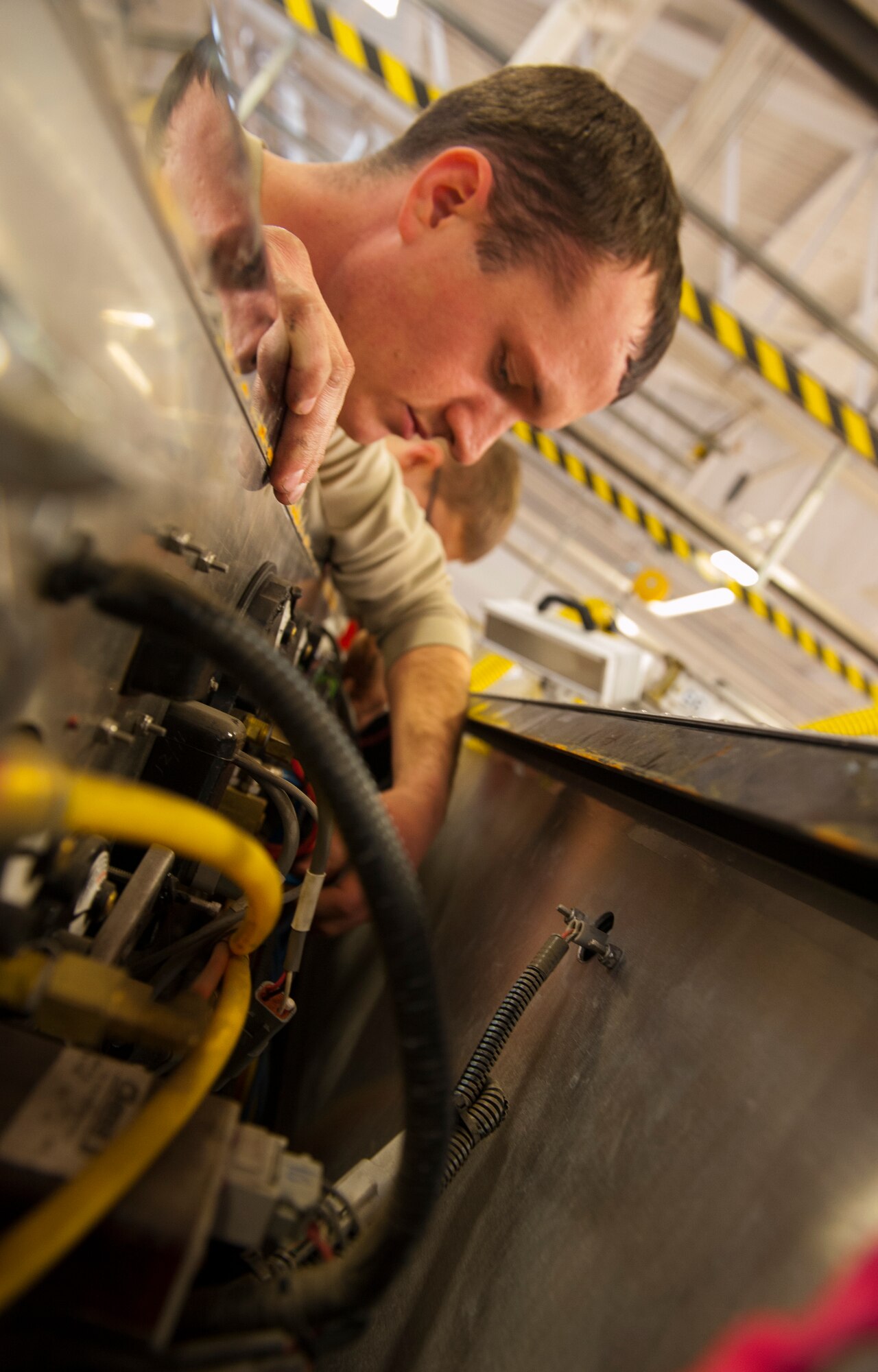 Senior Airman Brett Randolph, 5th Logistics Readiness Squadron fire truck maintainer, works on a fire truck at the Minot Air Force Base fire house, Jan. 28, 2014. Vehicle mechanics at Minot AFB maintain the government vehicles at 11 different facilities across base. (U.S. Air Force photo/Airman 1st Class Apryl Hall)