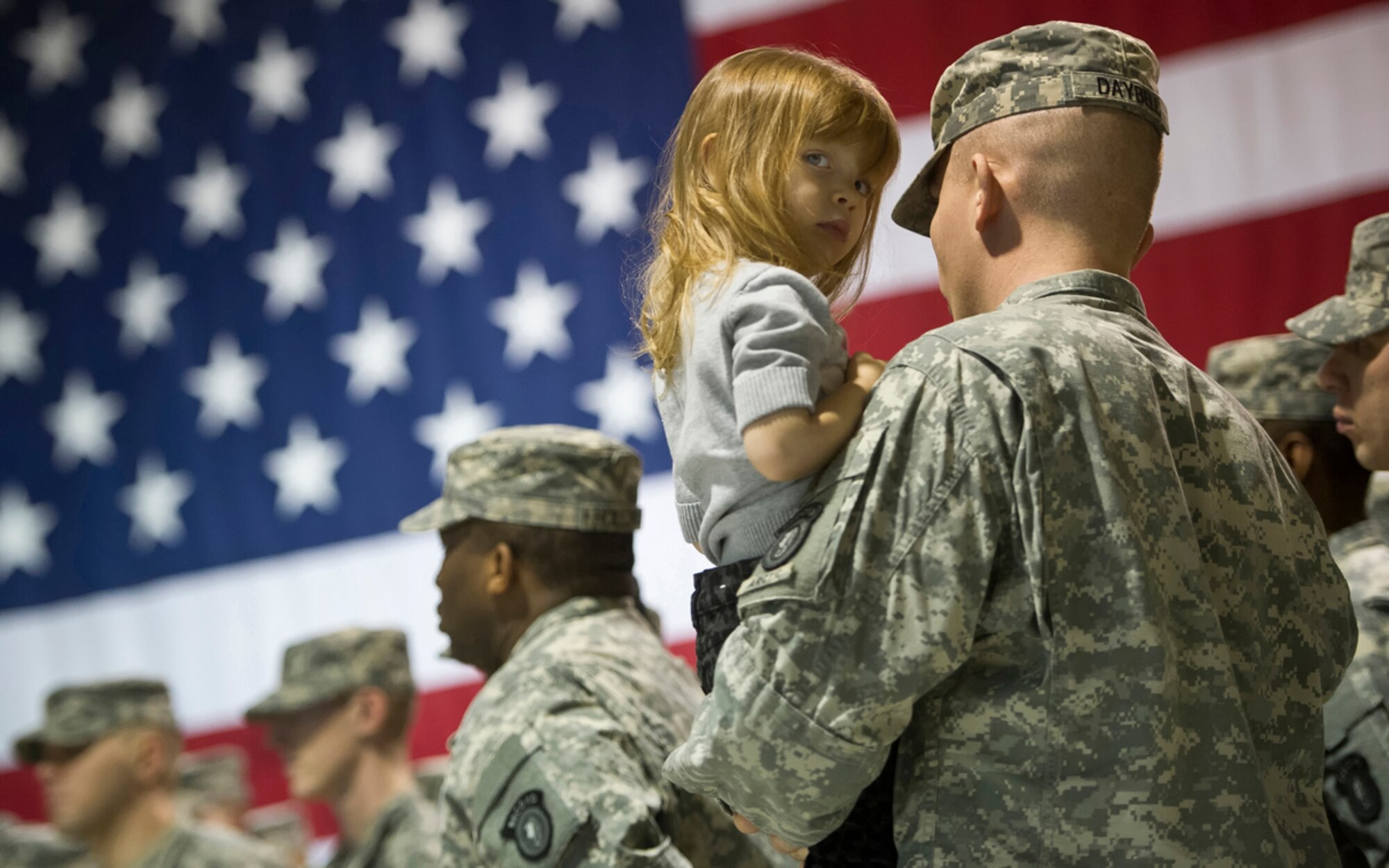 Army 2nd Lt. Jeffrey Daybell, assigned to the 164th Military Police Company, 793rd Military Police Battalion, 2d Engineer Brigade, U.S. Army Alaska, a native of Chantilly, Va., holds his 2-year-old daughter Madilyn, after a deployment ceremony for his unit at the Alaska National Guard Armory, Thursday, Jan. 23, 2014, on Joint Base Elmendorf-Richardson, Alaska.  Daybell and his fellow Soldiers are deploying for about five months to the island of Guam to provide site security for a facility there. As part of the deployment ceremony the company was awarded the prestigious Command Sgt. Maj. Farley Award for being the best military police company in U.S. Army Pacific. The award was presented by retired Army Command Sgt. Maj. Mark L. Farley himself, who was the first enlisted military police Soldier to lead as the senior enlisted adviser at the 2, 3 and 4-star level commands, eventually retiring as the command sergeant major of U.S. Army Europe. (U.S. Air Force photo/Justin Connaher)