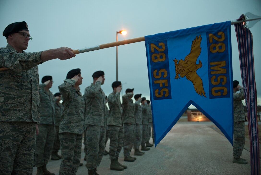 Members of the 28th Security Forces Squadron salute the flag during a retreat ceremony at Ellsworth Air Force Base, S.D., Jan. 29, 2014. Each month, one squadron on base performs a retreat ceremony at the base flagpole to remember and honor its Air Force heritage. (U.S. Air Force photo by Senior Airman Alystria Maurer/Released)