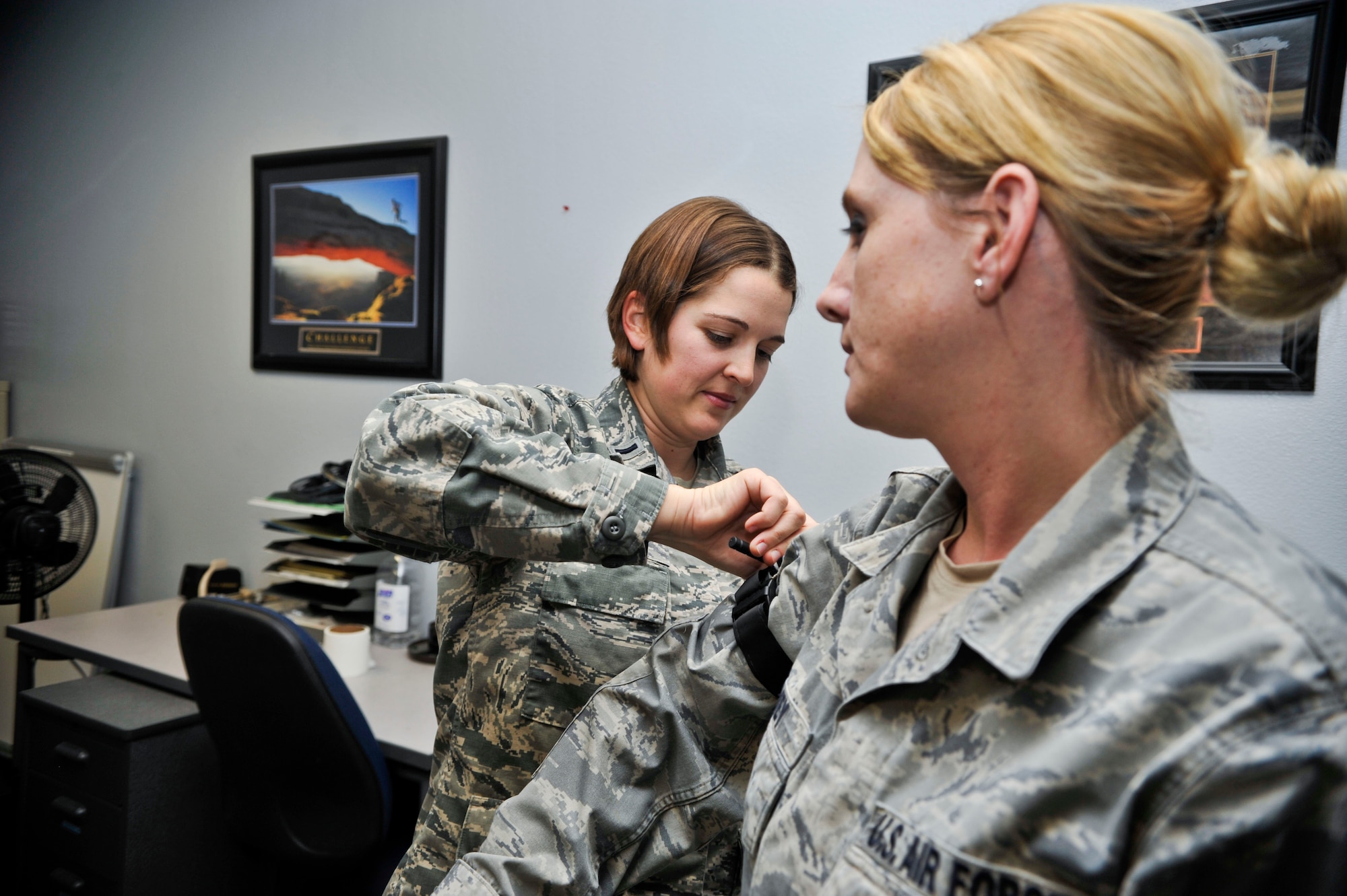 First Lt. Marissa Rossi, 56th Fighter Wing protocol chief, tightens a tourniquet on the arm of Master Sgt. Cindy Spivey, 56th Comptroller Squadron financial analysis NCO-in-charge, Jan. 17 during the hands-on portion of the self aid buddy care training. (U.S. Air Force photo/Senior Airman David Owsianka)