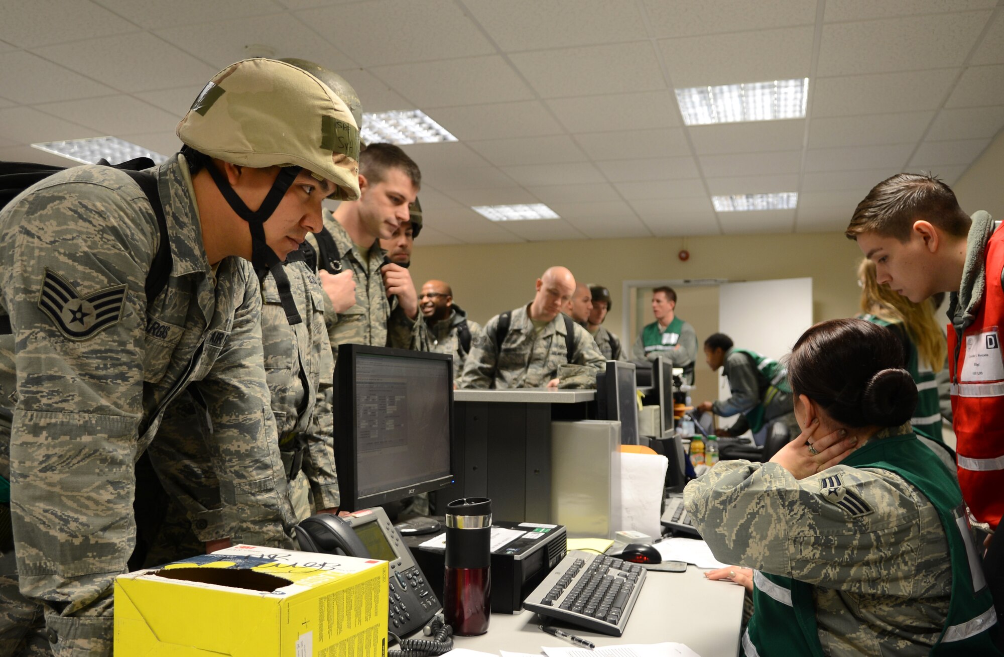 U.S. Air Force Staff Sgt. Jose Vargas, left, 100th Civil Engineer Squadron electric power production craftsman from El Paso, Texas, processes through a pre-deployment facility line Jan. 30, 2014, during a deployment exercise on RAF Mildenhall, England. The deployment exercise tested Team Mildenhall members’ ability to process through a pre-deployment facility quickly. The exercise was part of a base-wide operational readiness inspection, focused on assessing the base’s preparedness for real-world operations. (U.S. Air Force photo by Airman 1st Class Dillon Johnston/Released)