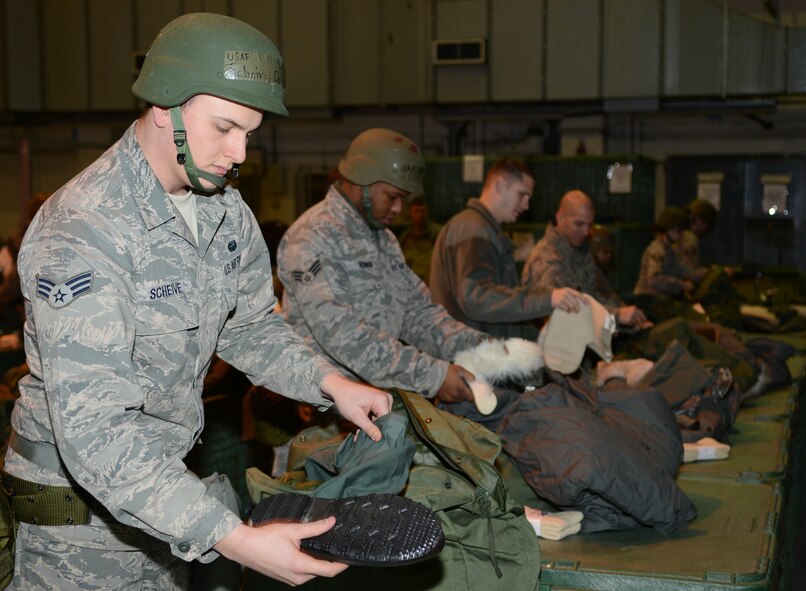 U.S. Air Force Senior Airman Darrin Scheive, left, 100th Communications Squadron client system technician from Brownsville, Calif., unpacks a mobility bag Jan. 30, 2014, during a deployment exercise on RAF Mildenhall, England. The deployment exercise tested Team Mildenhall members’ ability to quickly process through a pre-deployment facility. The exercise was part of the base’s operational readiness inspection, focused on assessing the base’s preparedness for real-world operations. (U.S. Air Force photo by Airman 1st Class Dillon Johnston/Released)