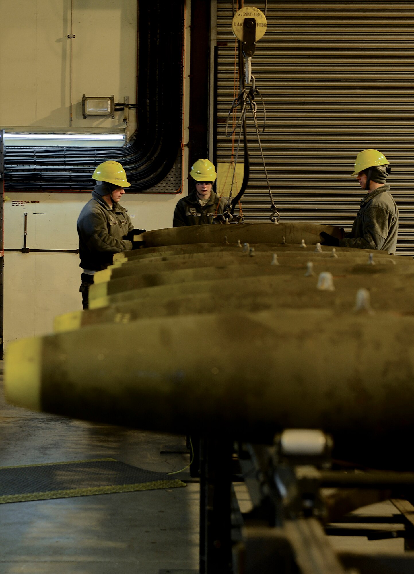 Airmen from the 48th Munitions Squadron load GBU-12 laser-guided bombs onto the assembly line Jan. 29, 2014, on Royal Air Force Lakenheath, England. The 48th MUNS Airmen are building the 500-pound bombs in preparation for an upcoming exercise. (U.S. Air Force photo by Airman 1st Class Dawn M. Weber/Released)