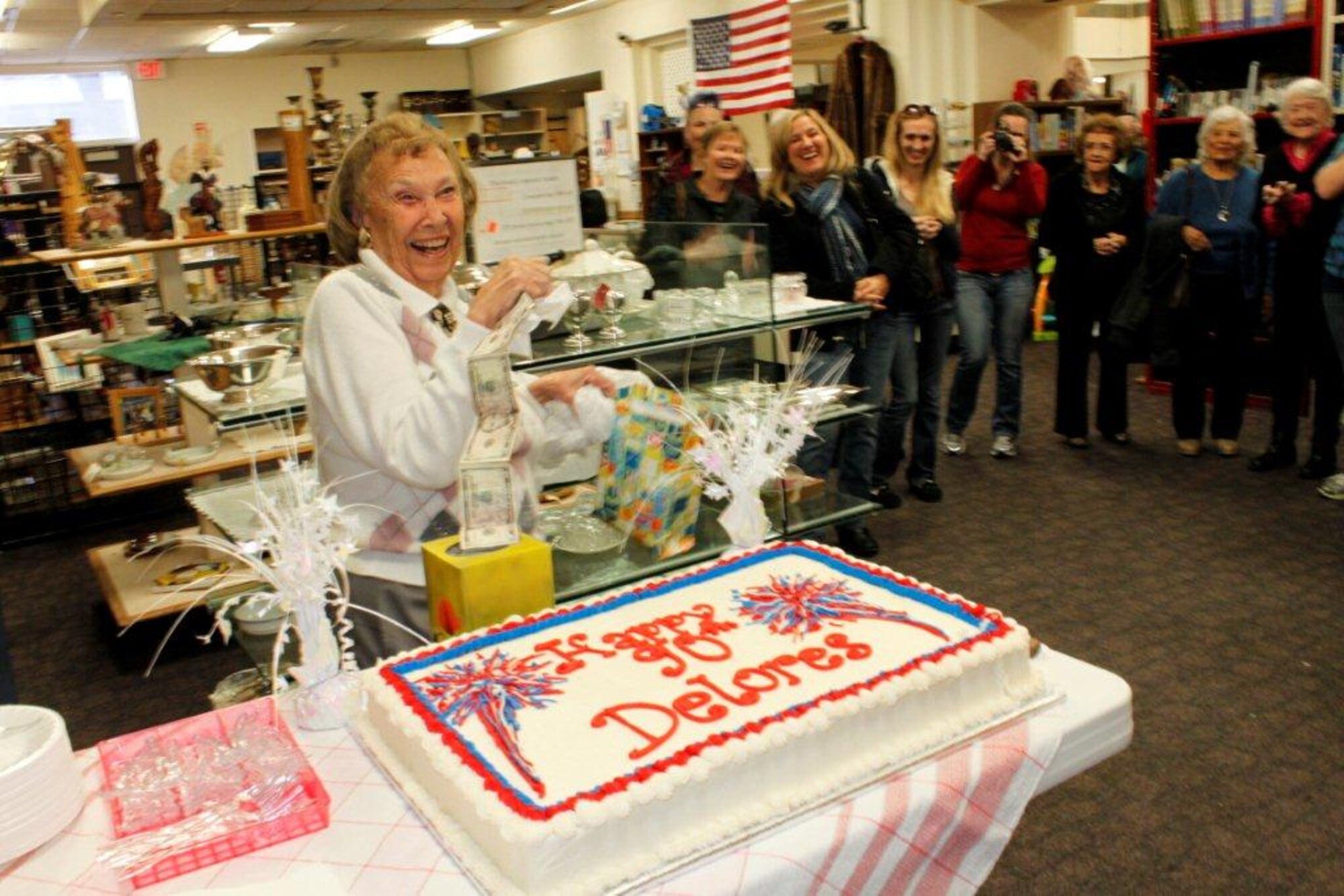 Delores Dicker, a volunteer at the Kirtland Spouses’ Club Thrift Shop, was surprised by her friends who through her a 90th birthday celebration. (Photo by Meredith Mingledorff)