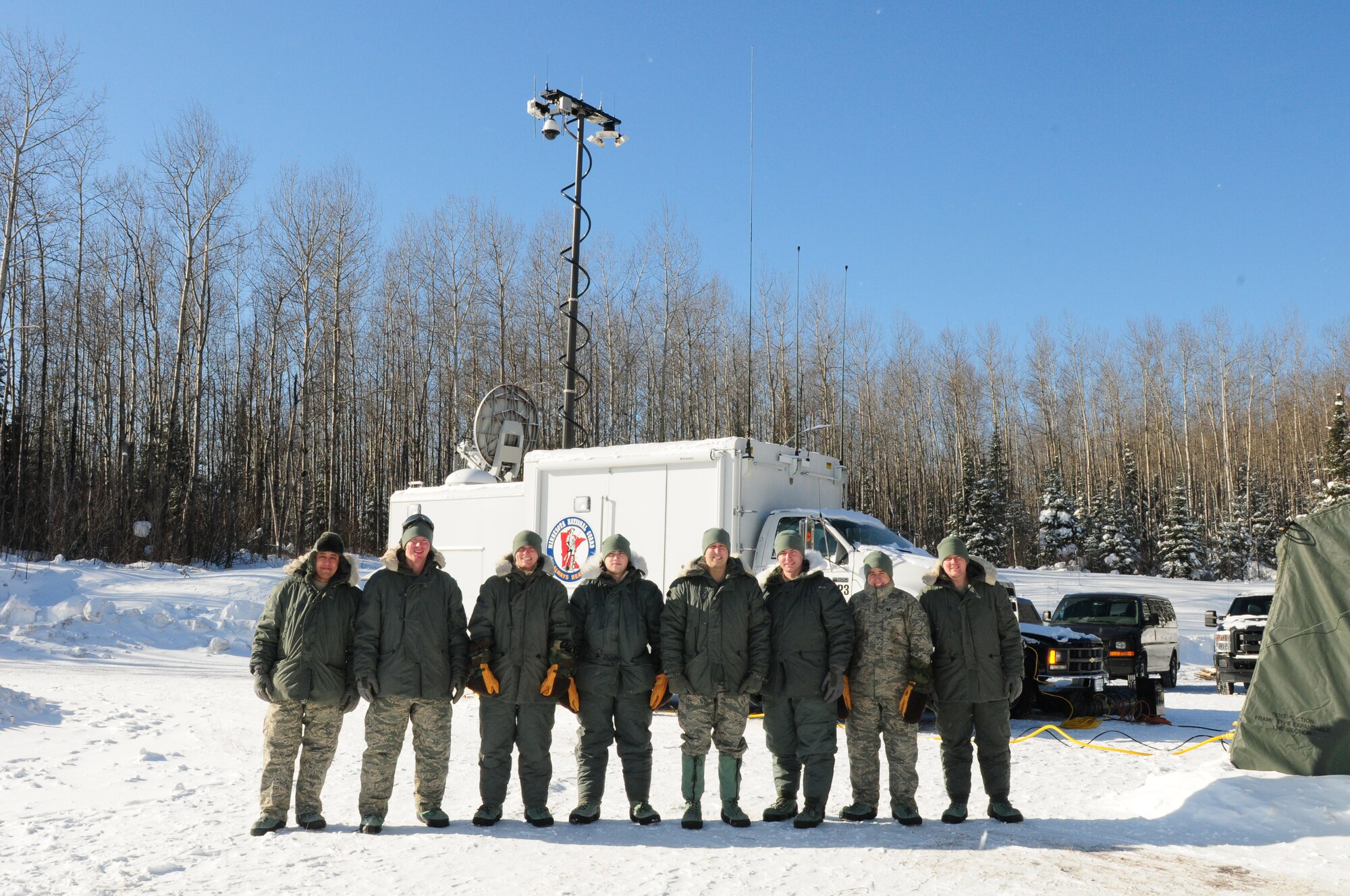 U.S. Airmen, 148th Fighter Wing, Communications Flight pose for a group photo at a remote location northwest of Grand Marais, Minn., Jan. 28, 2014.  The Airmen are part of the Deployable Interoperable Communications Element (DICE) team and were at the remote location to provide communication support for the John Beargrease sled dog marathon.  (U. S. Air National Guard photo by Master Sgt. Ralph J. Kapustka/Released)   