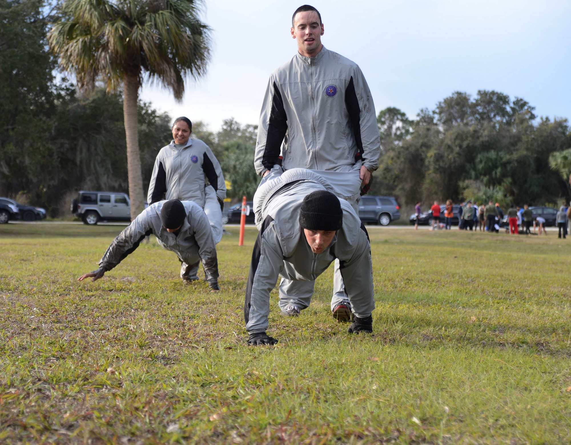 Members of the Joint Communications Support Element perform human wheel barrels during the Gladiator Assault Challenge, Jan. 24, 2014 at MacDill Air Force Base, Fla. The challenge is a 9.6 mile mix of outdoor obstacles and combined maneuvers planned to test endurance, speed, strength and agility with runs, crawls and jumps through the wet, mud and cold. (U.S. Air Force photo by Senior Airman Jenay Randolph/Released)
