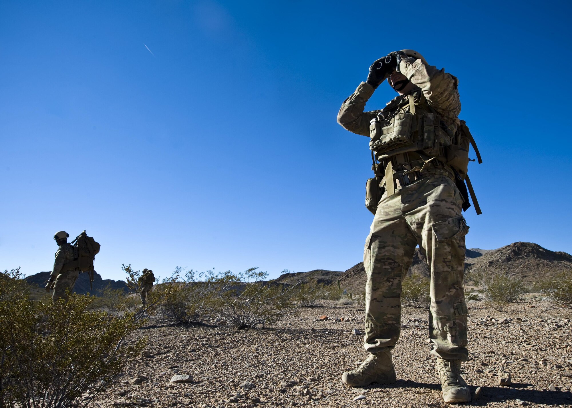 NELLIS AIR FORCE BASE, Nev. – Staff Sgt. Daniel Esselstrom, 23rd Civil Engineer Squadron, Moody AFB, Ga., performs long-range reconnaissance to locate emplaced IEDs.  During the Global Counter-IED Threat Assessment Course, here, EOD teams are tested with a wide variety of scenarios including missions navigating challenging terrain “on foot” with limited resources. (U.S. Air Force photo/Airman 1st Class Christopher Tam)