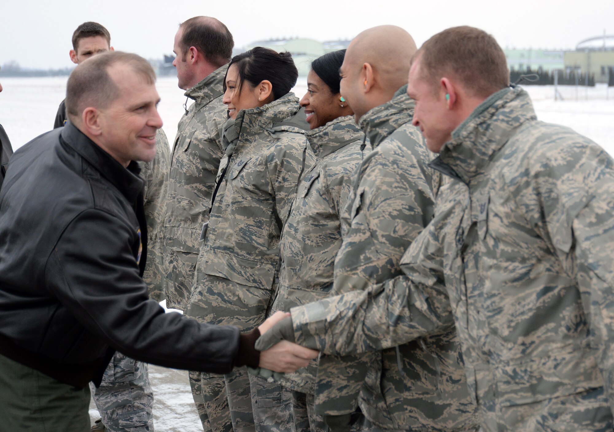 Col. Robert Winkler, 52nd Operations Group commander, shakes hands with Airmen assigned to Detachment 1, 52nd Operations Group on the flightline of Lask Air Base, Poland, Jan. 29, 2014. The mission of Detachment 1 is to foster bilateral defense ties, enhance regional security and increase interoperability among NATO allies through combined training exercises with periodic rotational aircraft. (U.S. Air Force photo by Staff Sgt. Joe W. McFadden / Released)