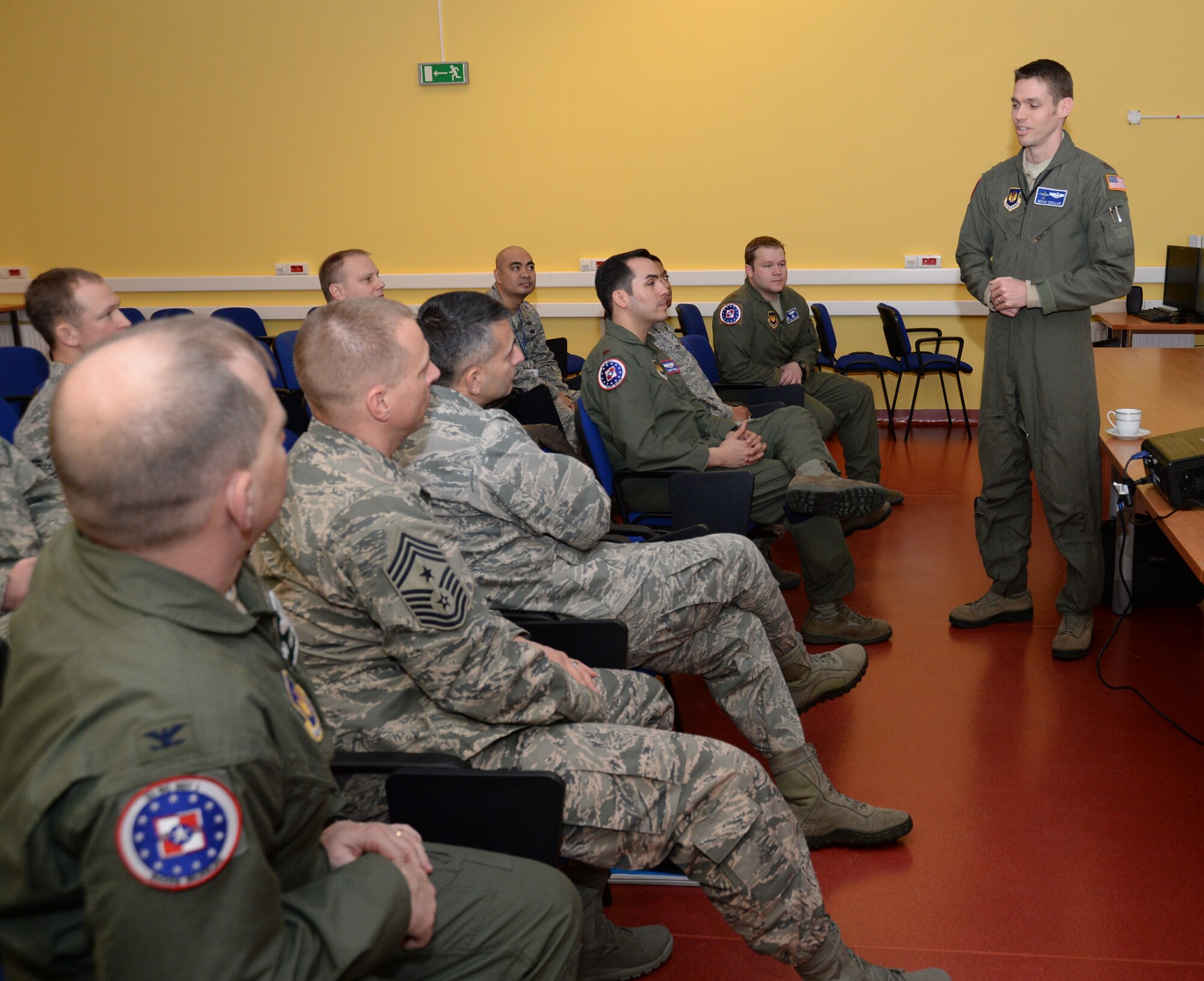 U.S. Air Force Maj. Micah Chollar, director of operations for Detachment 1, 52nd Operations Group, standing, briefs Col. David Julazadeh, 52nd Fighter Wing commander, and Chief Master Sgt. Matthew Grengs, 52nd FW command chief, during a tour of the detachment at Lask Air Base, Poland, Jan. 29, 2014. Ten Airmen assigned to the detachment augment the 52nd OG's facilitation of bilaterial and multinational joint theater security cooperation events. (U.S. Air Force photo by Staff Sgt. Joe W. McFadden / Released)