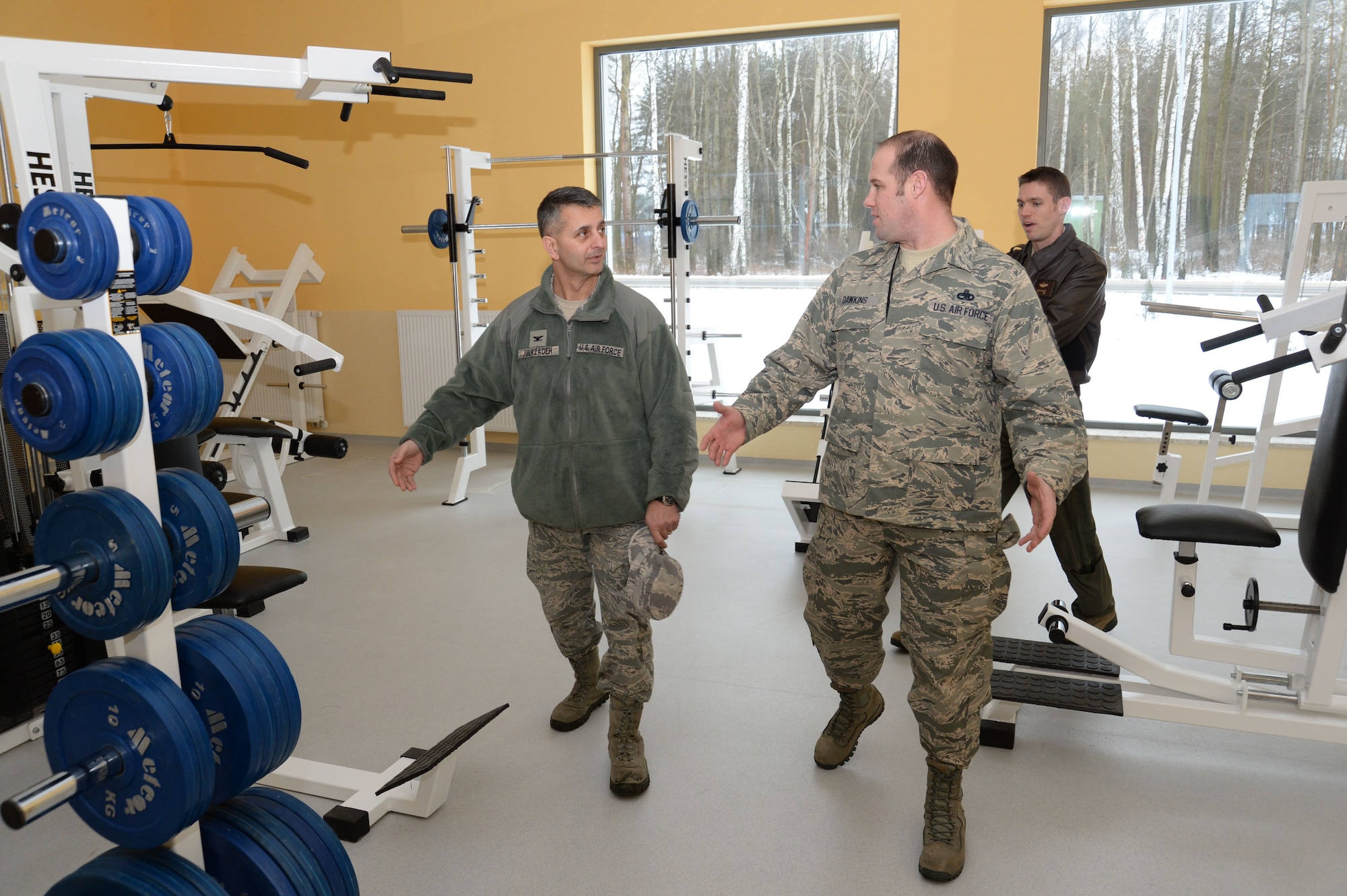 U.S. Air Force Col. David Julazadeh, commander of the 52nd Fighter Wing, left, listens as Master Sgt. Mark Dawkins, Detachment 1, 52nd Operations Group maintenance operations liaison, gives a tour of the fitness center at Lask Air Base, Poland, Jan. 29, 2014. Wing leadership toured the Polish installation's fitness center, swimming pool, obstacle course and indoor/outdoor tracks used by both Polish and American Airmen -- a shared usage also in line with the detachment's motto "Razem Silniejsi," meaning "Stronger Together" in Polish. (U.S. Air Force photo by Staff Sgt. Joe W. McFadden / Released)