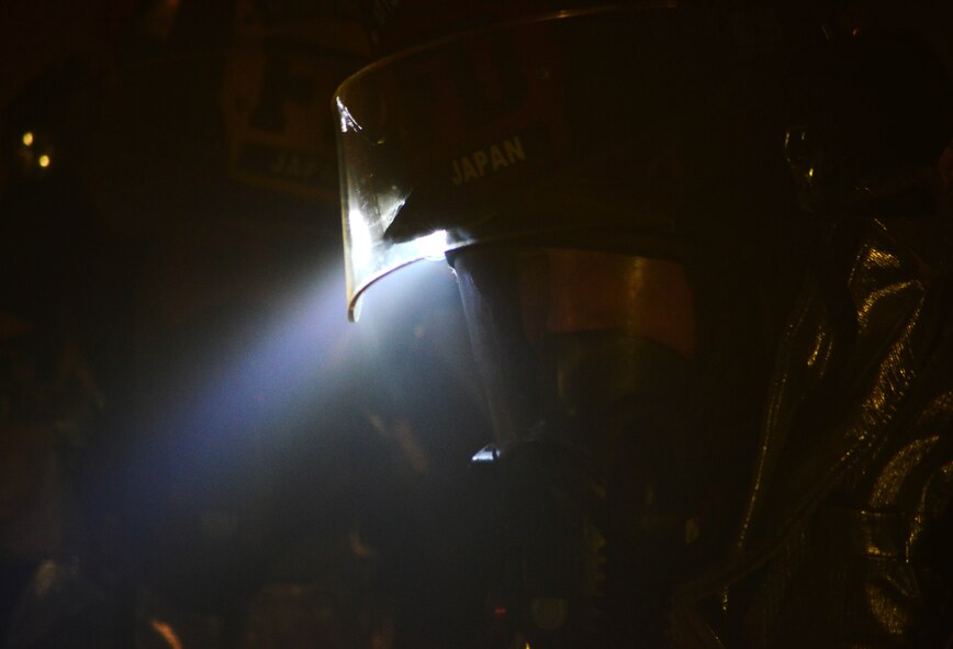 U.S. Air Force Airman 1st Class Benny Bowen, 35th Civil Engineer Squadron firefighter, searches through the smokey room in search of the 2 down wingmen during Phase II of the operational readiness exercise on Misawa Air Base, Japan, Jan. 29, 2014. These exercises are learning tools that help the firefighters hone their skills. (U.S. Air Force photo/Tech. Sgt. April Quintanilla)