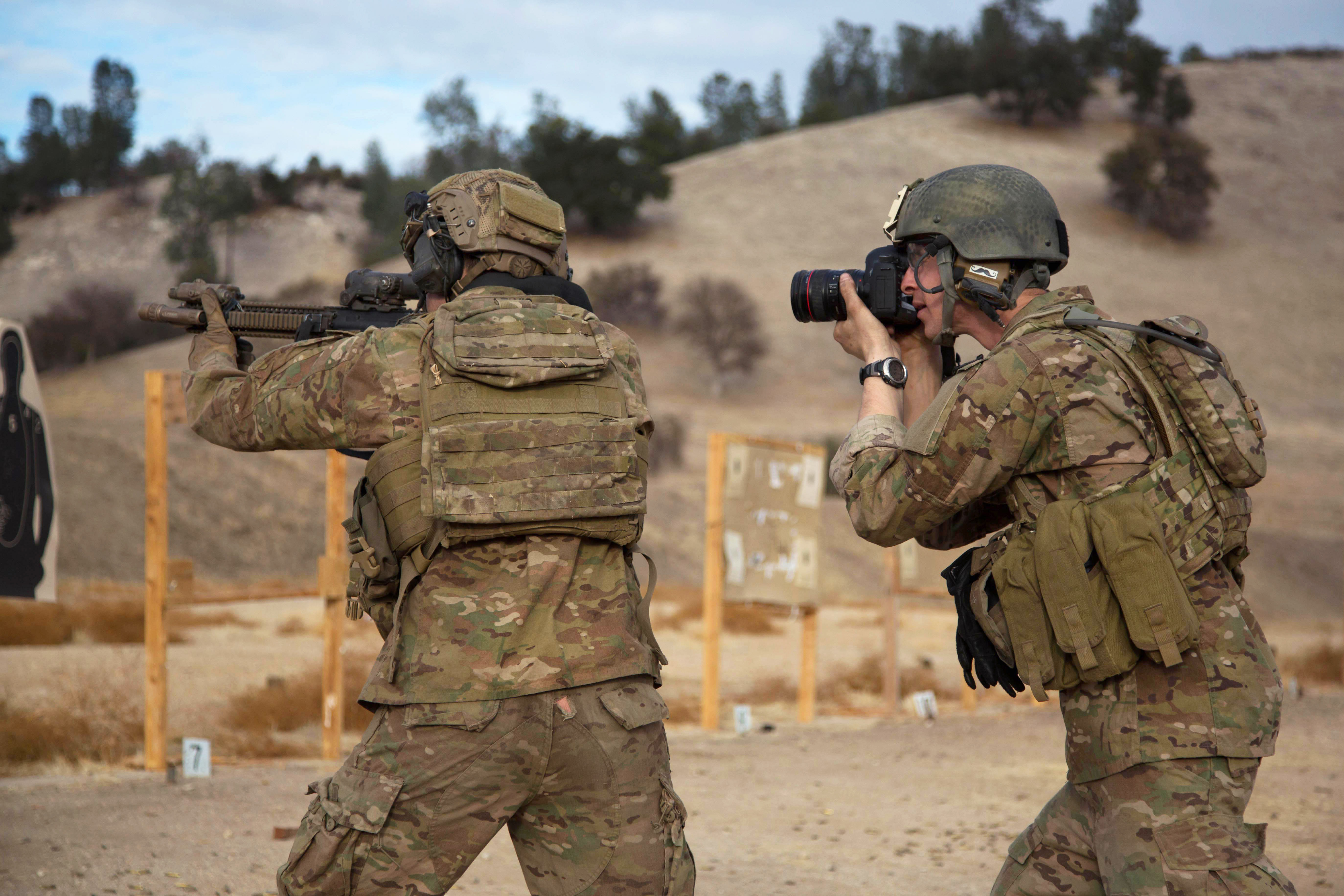 Army Spc. Steven Hitchcock, right, takes photographs of Army Rangers