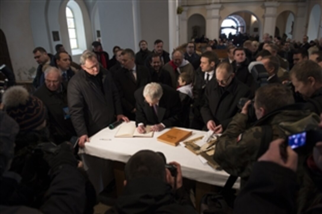 U.S. Defense Secretary Chuck Hagel signs a guestbook at Dabrowka Church in Kiszkowo, a village in western Poland, Jan. 31, 2014. The church, rebuilt after a fire, is on the same site where Hagel's great grandparents were married. Hagel is on a trip to Europe to meet with defense leaders and attend the 50th Munich Security Conference.
