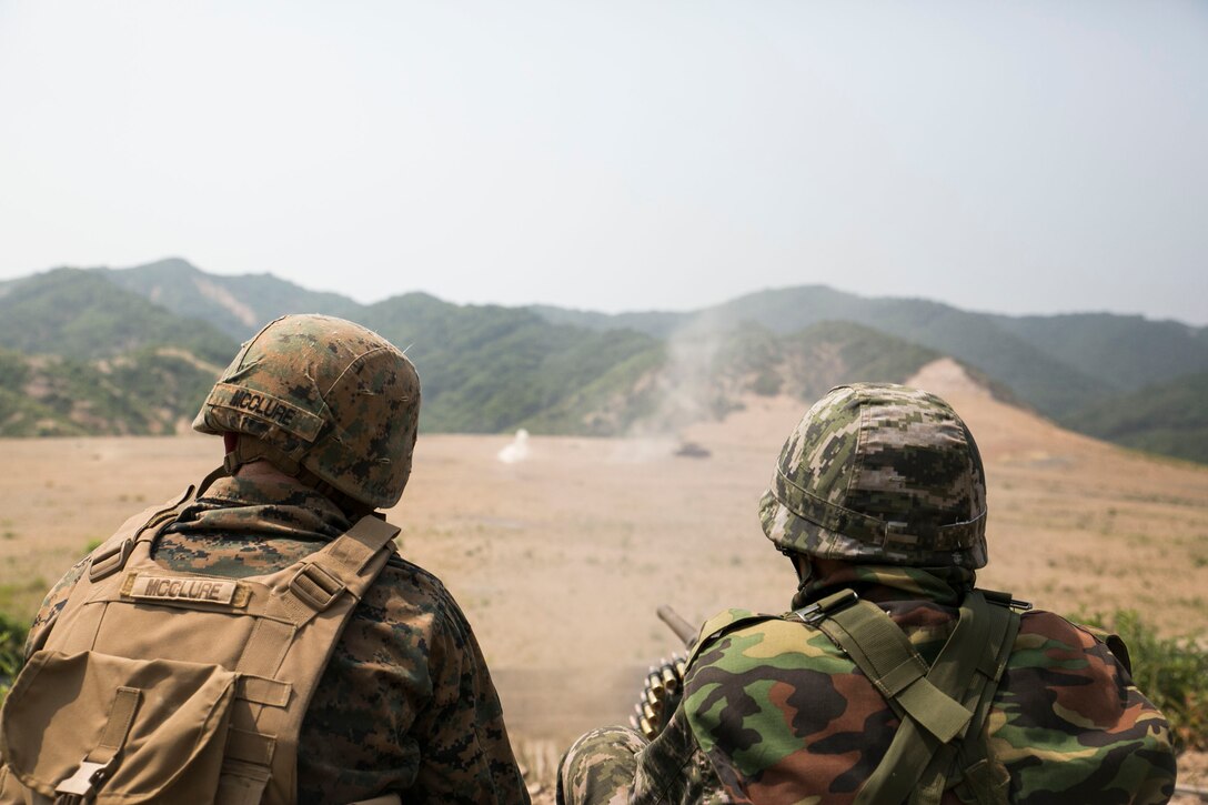 A Republic of Korea Marine, right, fires an M2 .50-caliber Browning machine gun as U.S. Marine Lance Cpl. Remington J.O. McClure observes June 19 during integrated live-fire training as part of Korean Marine Exchange Program 14-8 at the Susungri range in Pohang. ROK and U.S. Marines used various weapons systems as part of an integrated live-fire range to enhance their combined combat proficiency. KMEP 14-8 is a combined, small-unit training exercise, which enhances the combat readiness and interoperability of ROK and U.S. Marine Corps forces. The exercise also highlights the two countries’ combined commitment to the defense of South Korea and peace and security in the region. McClure is a Milton, West Virginia, native and military policeman with Company C, 3rd Law Enforcement Battalion, III Marine Expeditionary Force Headquarters Group, III MEF. (U.S. Marine Corps photo by Lance Cpl. Drew Tech/Released)