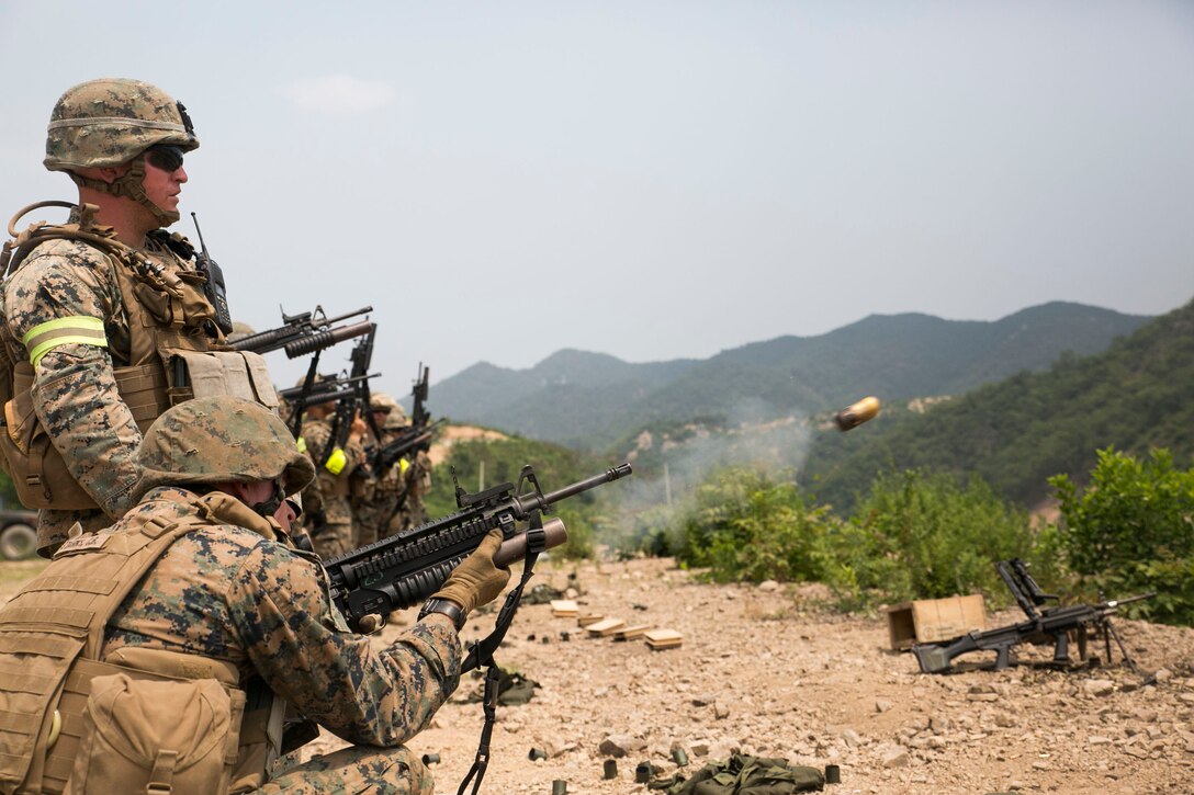 Lance Cpl. Cody B. Starks, bottom left, fires an M203 40 mm grenade launcher as Lance Cpl. Anthony J. Pellegrini, standing left, looks on June 19 during integrated live-fire training as part of Korean Marine Exchange Program 14-8 at the Susungri range in Pohang. ROK and U.S. Marines used various weapons systems as part of an integrated live-fire range to enhance their combined combat proficiency. KMEP 14-8 is a combined, small-unit training exercise, which enhances the combat readiness and interoperability of ROK and U.S. Marine Corps forces. The exercise also highlights the two countries’ combined commitment to the defense of South Korea and peace and security in the region. Starks is a Benton, Kentucky native, and Pellegrini is a Pompton Lakes, New Jersey native. Both are military policemen with Company C, 3rd Law Enforcement Battalion, III Marine Expeditionary Force Headquarters Group, III MEF. (U.S. Marine Corps photo by Lance Cpl. Drew Tech/Released)
