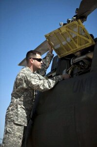 Army Chief Warrant Officer 2 Jonathan Sigl performs a pre-flight inspection on an OH-58 Kiowa aircraft in Marana, Ariz. Sigl is part of a North Dakota National Guard flight crew participating with Task Force Raven of the Southwest Border mission.