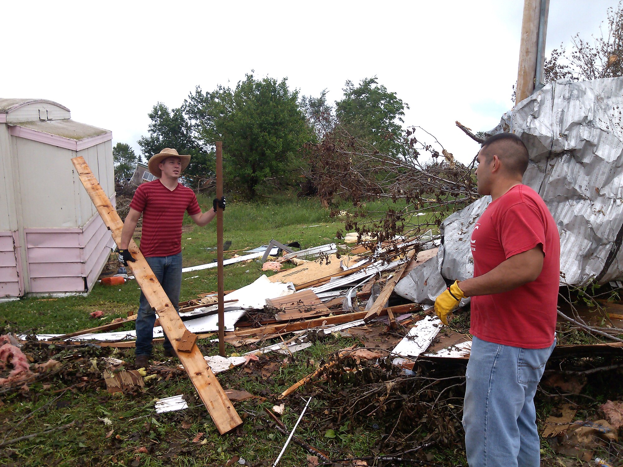 Senior Airman Charles Little, left, and Airman 1st Class Stephen Robles help remove debris June 22, 2014 in Wakefield, Nebraska. They volunteered to help with the cleanup of Wakefield following a tornado that struck the town June 16, 2014. Little and Robles are contracting specialists from the 55th Contracting Squadron. (Courtesy photo)