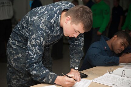 A U.S. Sailor lines up to register for the 2012 presidential election and to submit an absentee ballot request. Personnel and their families are urged to apply early for ballots.