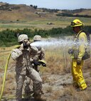 Marines with 2nd Battalion, 11th Marine Regiment, 1st Marine Division, I Marine Expeditionary Force, extinguish a simulated fire during a Woodland Firefighting Course aboard Marine Corps Base Camp Pendleton, Calif., June 26, 2014. The weeklong training was led by firefighters from the California Department of Forestry and Fire Protection and the Camp Pendleton Fire Department. (U.S. Marine Corps Photo by Lance Cpl. Tony Simmons)
