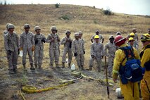 Marines with 2nd Battalion, 11th Marine Regiment, 1st Marine Division, I Marine Expeditionary Force, are taught the proper way to lay hoses during a Woodland Firefighting Course aboard Marine Corps Base Camp Pendleton, Calif., June 26, 2014. The weeklong training was led by firefighters from the California Department of Forestry and Fire Protection and the Camp Pendleton Fire Department. (U.S. Marine Corps Photo by Lance Cpl. Tony Simmons)