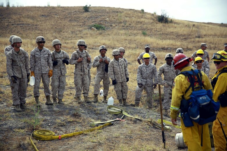 Marines with 2nd Battalion, 11th Marine Regiment, 1st Marine Division, I Marine Expeditionary Force, are taught the proper way to lay hoses during a Woodland Firefighting Course aboard Marine Corps Base Camp Pendleton, Calif., June 26, 2014. The weeklong training was led by firefighters from the California Department of Forestry and Fire Protection and the Camp Pendleton Fire Department. (U.S. Marine Corps Photo by Lance Cpl. Tony Simmons)