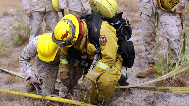 Marines with 2nd Battalion, 11th Marine Regiment, 1st Marine Division, I Marine Expeditionary Force, learn how to cut off water pressure while progressively laying hoses during a Woodland Firefighting Course aboard Marine Corps Base Camp Pendleton, Calif., June 26, 2014. The weeklong training was led by firefighters from the California Department of Forestry and Fire Protection and the Camp Pendleton Fire Department. (U.S. Marine Corps Photo by Lance Cpl. Tony Simmons)