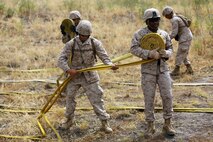 Marines with 2nd Battalion, 11th Marine Regiment, 1st Marine Division, I Marine Expeditionary Force, re-roll hoses during a Woodland Firefighting Course aboard Marine Corps Base Camp Pendleton, Calif., June 26, 2014. The weeklong training was led by firefighters from the California Department of Forestry and Fire Protection and the Camp Pendleton Fire Department. (U.S. Marine Corps Photo by Lance Cpl. Tony Simmons)