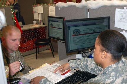 Army Spc. Jacqueline Clayton, a human resources specialist at Camp Shelby Joint Forces Training Center, assists Army Sgt. Andrew Hardin, D Company, 1-279th Infantry Regiment, 45th Infantry Brigade Combat Team, to enroll for benefits with the Veterans Affairs new online application during demobilization.