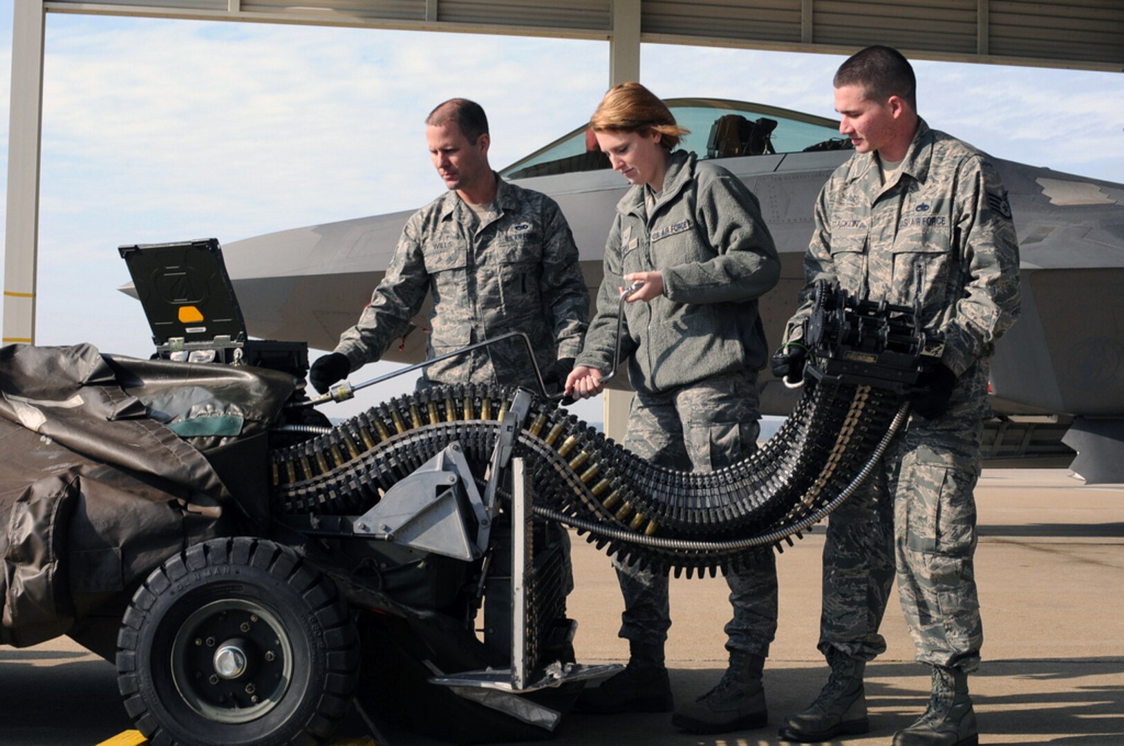 Air Force Staff Sgt. Christopher Stacklin, Air Force Airman First Class Darby Ryan and Air Force Staff Sgt. Greg Wills, 192nd Fighter Wing, Virginia Air National Guard F-22 Raptor weapons loaders, 27th Aircraft Maintenance Unit, conduct an inspection on a Universal Ammunition Loading System, Langley Air Force Base, Va., January 26, 2012. The Maintenance and Operations Groups of the 192nd Fighter Wing were each recently selected to receive an Air Force Outstanding Unit Award for their accomplishments over the past two years. (U.S. Air Force photo by Master Sgt. Carlos Claudio) (Released)