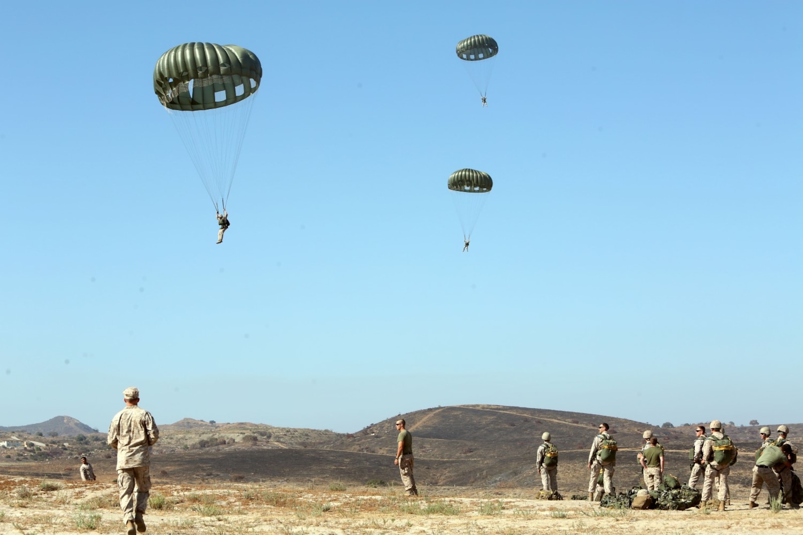 Marines and Sailors with Company C, 1st Reconnaissance Battalion, guide themselves toward their target landing zone during a static line jump from a CH-43E helicopter aboard Marine Corps Base Camp Pendleton, Calif., June 25, 2014. The company practiced both freefall and static line jumps from a CH-43 helicopter to better prepare for potential combat operations anywhere they are needed worldwide.