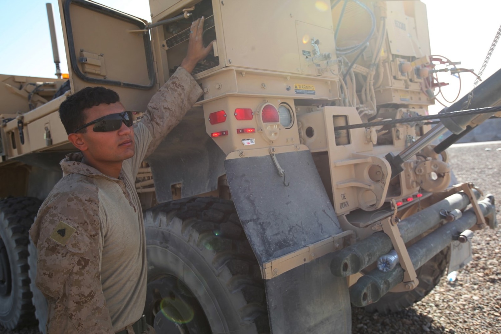 Corporal Anthony Casares, a wrecker operator with Marine Wing Support Squadron 274, operates a Logistics Vehicle System Replacement MKR15 wrecker while removing an empty 210,000-gallon bulk fuel bladder aboard Camp Bastion, Afghanistan, June 28, 2014. In three hours' time, more than 15 Marines with MWSS-274 and 15 contractors removed the last one of eight non-Marine Corps owned bulk fuel bladders at the bulk fuel site. (U.S. Marine Corps photo by Cpl. Cody Haas/ Released)