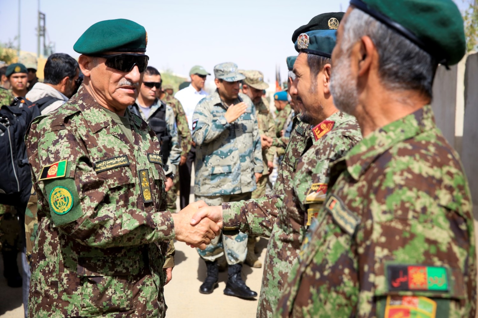 Afghan National Army (ANA) Gen. Shir Mohammad Karimi, chief of army staff, shakes hands with ANA officers, assigned to the 215th Corps, aboard Camp Shorabak, Helmand province, Afghanistan, June 27, 2014. Karimi visited with ANA leaders and ISAF advisors to discuss the military matters in the southwest region of Afghanistan.
(Official U.S. Marine Corps photo by Lance Cpl. Darien J. Bjorndal, Marine Expeditionary Brigade Afghanistan/ Released)
