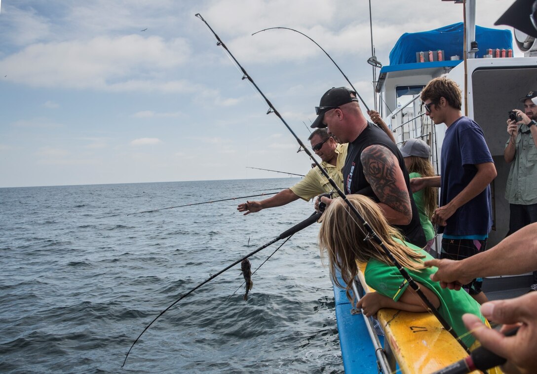 Service members reel in their catches during a youth fishing trip aboard the fishing vessel Dana Pride off the coast of Southern California, June 26, 2014. More than 30 service members and children participated in the event. (U.S. Marine Corps photo by Cpl. Emmanuel Ramos/Released)
