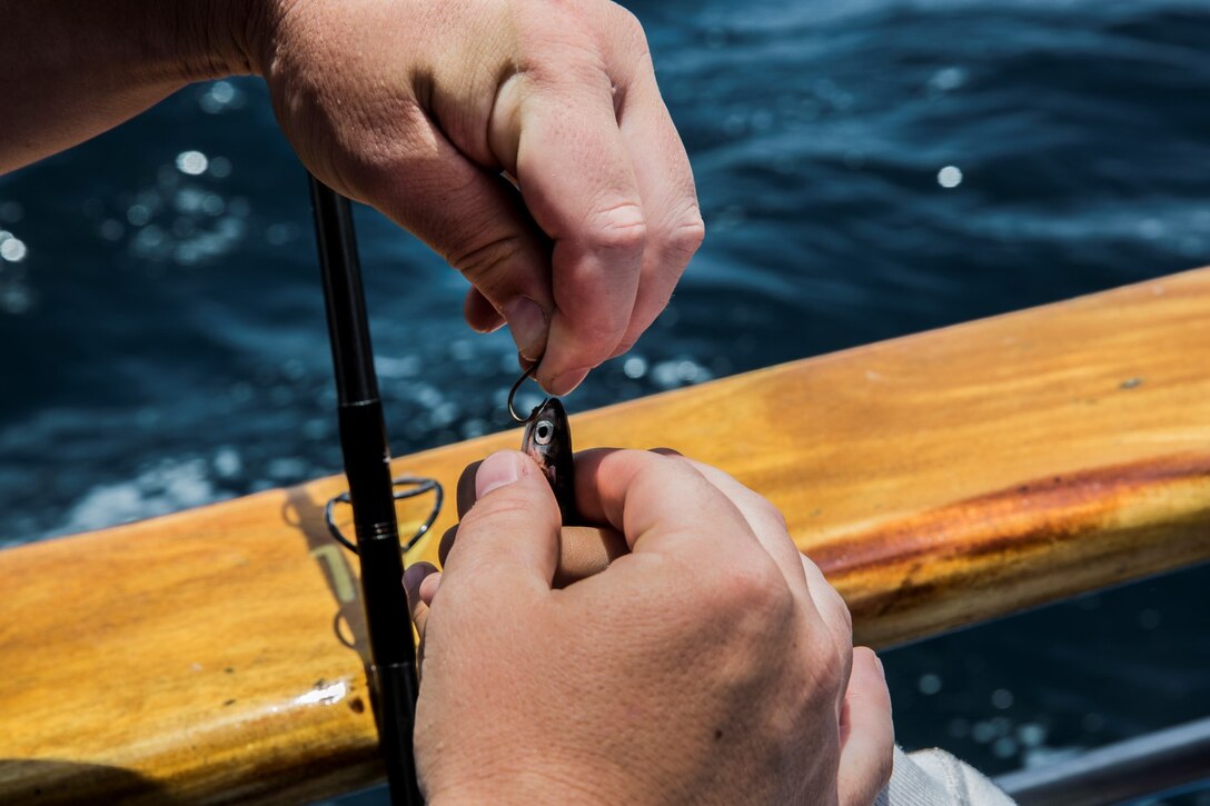 Sergeant Sigilfredo Garcia, small-arms technician, 15th Marine Expeditionary Unit, baits a hook for his daughter Aubry, 6, during a youth fishing trip aboard the fishing vessel Dana Pride off the coast of Southern California, June 26, 2014. More than 30 service members and children participated in the event. (U.S. Marine Corps photo by Cpl. Emmanuel Ramos/Released)