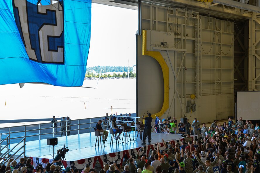 DeShawn Shead (center) Seattle Seahawks cornerback, takes a selfie with his phone July 1, 2014, including the cheering fans in the background during the 2014 Seattle Seahawks 12 Tour at Joint Base Lewis-McChord, Wash. After answering questions for the crowd, Shead and other players signed autographs and took pictures with fans. (U.S. Air Force photo/Staff Sgt. Russ Jackson)