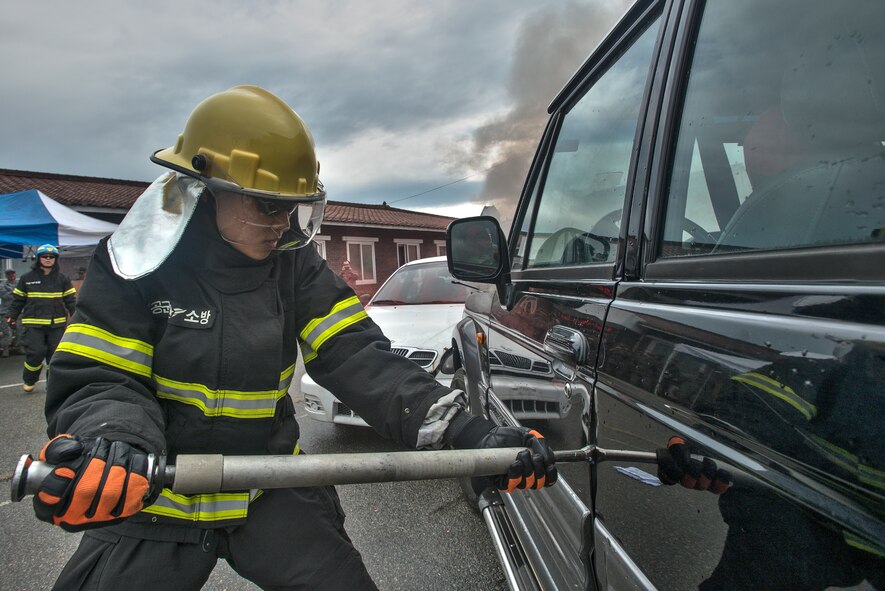 A firefighter prys open the door of a vehicle April 29, 2014, at Osan Air Base, Republic of Korea. Firefighters from the U.S. and RoK scheduled training together to enhance their response abilities during a contingency. (U.S. Air Force photo by Staff Sgt. Jake Barreiro)
