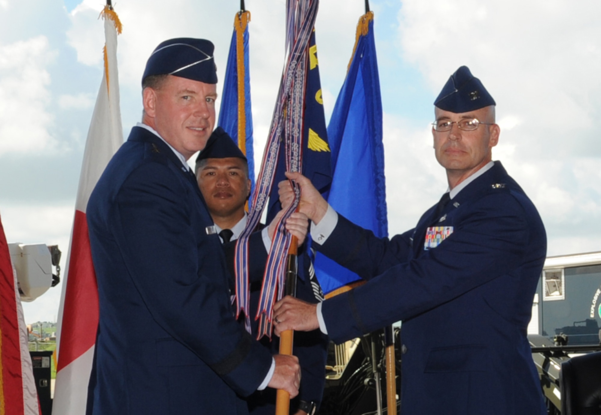 U.S. Air Force Brig. Gen. James B. Hecker, 18th Wing commander, hands off the group guidon to Col. Dwayne M. Robison, 18th Civil Engineer Group commander, during the change of command ceremony on Kadena Air Base, Japan, July 2, 2014. Base support executed by the 18th CEG includes explosive ordnance disposal, fire and emergency services, environmental protection, maintenance and refuse contracts, housing and housing maintenance island-wide, and base infrastructure. (U.S. Air Force photo by Airman 1st Class Zackary A. Henry)
