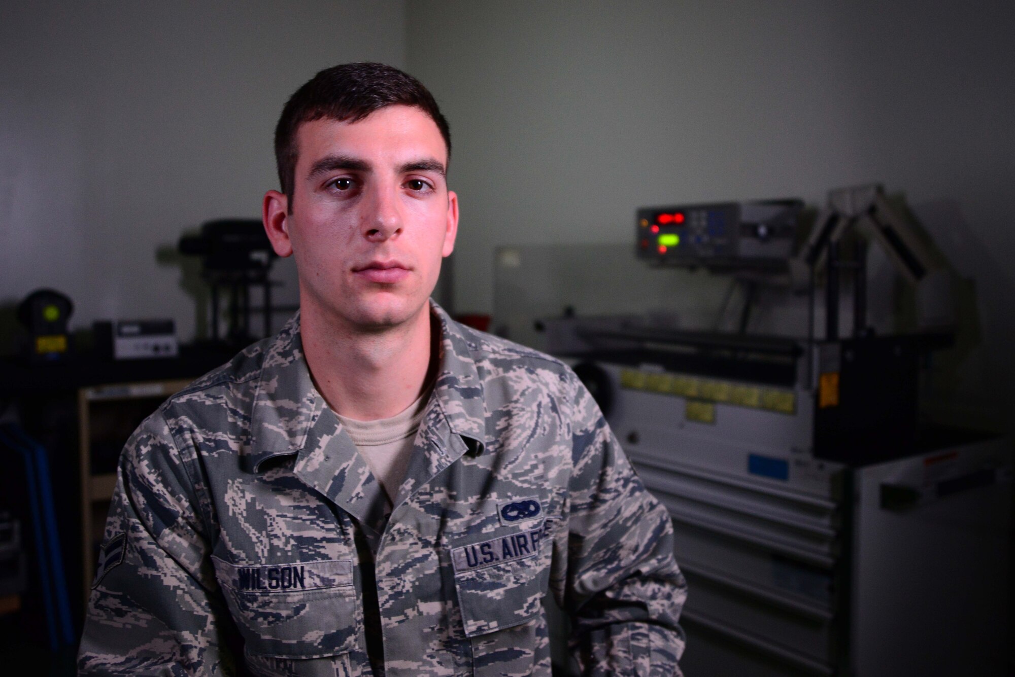 Airman 1st Class Jonathan Wilson, 35th Maintenance Squadron Precision Measurement Equipment Laboratory technician, poses for a photo in front of a torque wrench calibrator at Misawa Air Base, Japan, June 26, 2014. As part of the PMEL flight, Wilson and his coworkers calibrate more than 4,000 units annually for multiple agencies across base. (U.S. Air Force photo/Senior Airman Derek VanHorn)