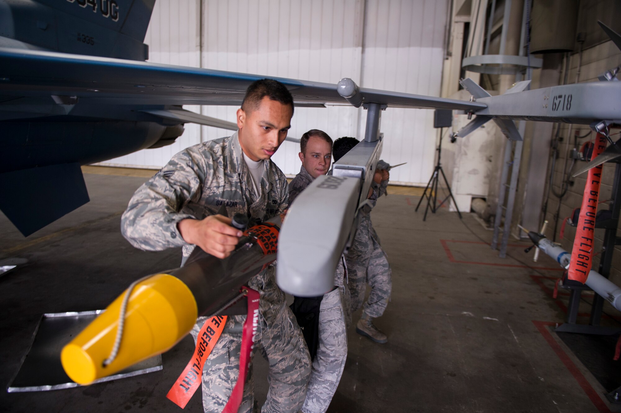 U.S. Air Force Senior Airman Zachary Salazar, Staff Sgt. Jason Macklin, and Airman 1st Class Christopher Rosadd, 354th Aircraft Maintenance Squadron, secure an AIM-9 Sidewinder missile during a load crew competition June 30, 2014, Eielson Air Force Base, Alaska. Macklin led his crew in the competition that highlighted Eielson’s top performing load crews of the second quarter for the year. (U.S. Air Force photo by Senior Airman Joshua Turner/Released)