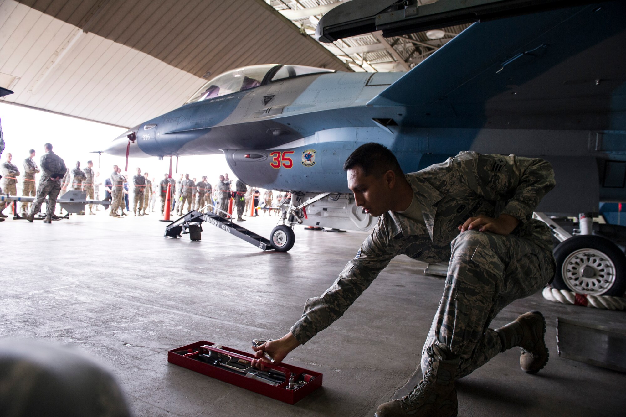 U.S. Air Force Senior Airman Zachary Salazar, 354th Maintenance Squadron armament technician, grabs tools during a load crew competition June, 30 2014, Eielson Air Force Base, Alaska. The competition pitted two load crews against each other to evaluate who could prepare the aircraft for combat the quickest and with the fewest procedural errors. (U.S. Air Force photo by Senior Airman Joshua Turner/Released)