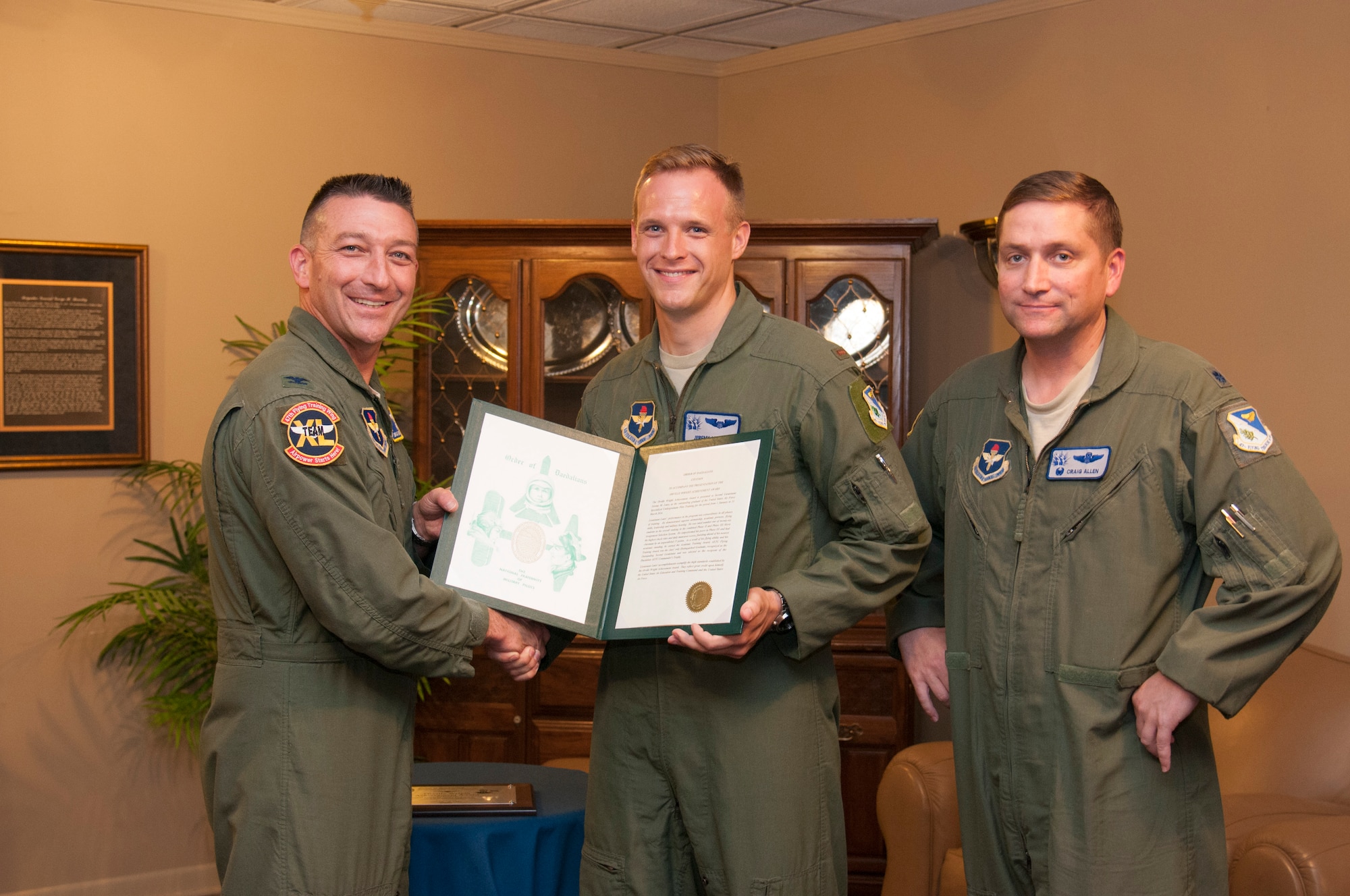 Second Lt. Jeremy Lutes, center, a 47th Student Squadron graduate, poses with Col. Brian Hastings, left, 47th Flying Training Wing commander, and Lt. Col. Craig Allen, right, unit job title, after receiving the Order of the Daedalians’ Orville Wright Achievement Award at Club XL on Laughlin Air Force Base, Texas, June 26, 2014. The Orville Wright Achievement Award is presented to students who show outstanding work in academic and leadership scenarios. (U.S. Air Force photo by Airman 1st Class Jimmie D. Pike)(Released)