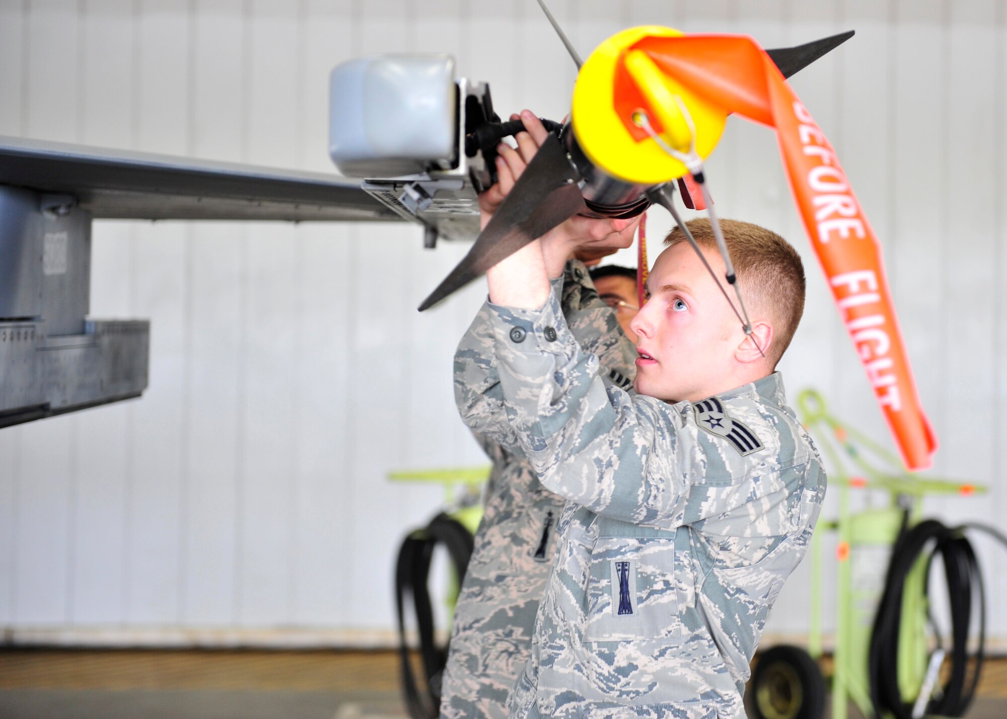 U.S. Air Force Senior Airman Nicholas Carter, 354th Aircraft Maintenance Squadron weapons load crew member, works with teammates to secure an AIM-9 Sidewinder missile during a load crew competition June 30, 2014, Eielson Air Force Base, Alaska. Points are awarded during weapons loading, tool kit inspection and uniform inspection for the competition. (U.S. Air Force photo by Senior Airman Ashley Nicole Taylor/Released)
