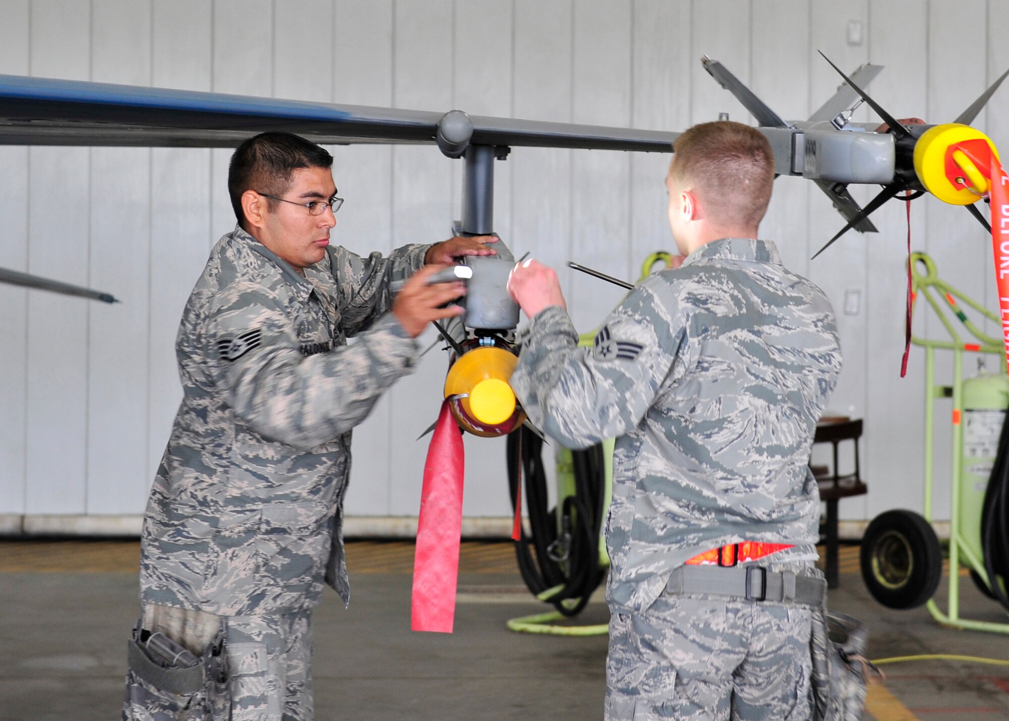 U.S. Air Force Staff Sgt. Jacob Maldonado, 354th Aircraft Maintenance Squadron weapons team chief, and Senior Airman Nicholas Carter, 354th AMXS weapons load crew member, perform final inspections on an F-16 Fighting Falcon during a load crew competition June 30, 2014, Eielson Air Force Base, Alaska. The competition pitted two load crews against each other to evaluate who could prepare the aircraft for combat the quickest and with the fewest procedural errors. (U.S. Air Force photo by Senior Airman Ashley Nicole Taylor/Released) 